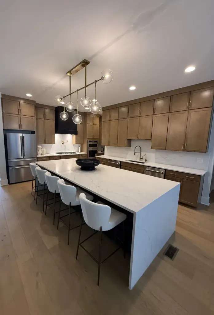 Warm wood kitchen with a white quartz waterfall island showing 2026 kitchen countertop trends