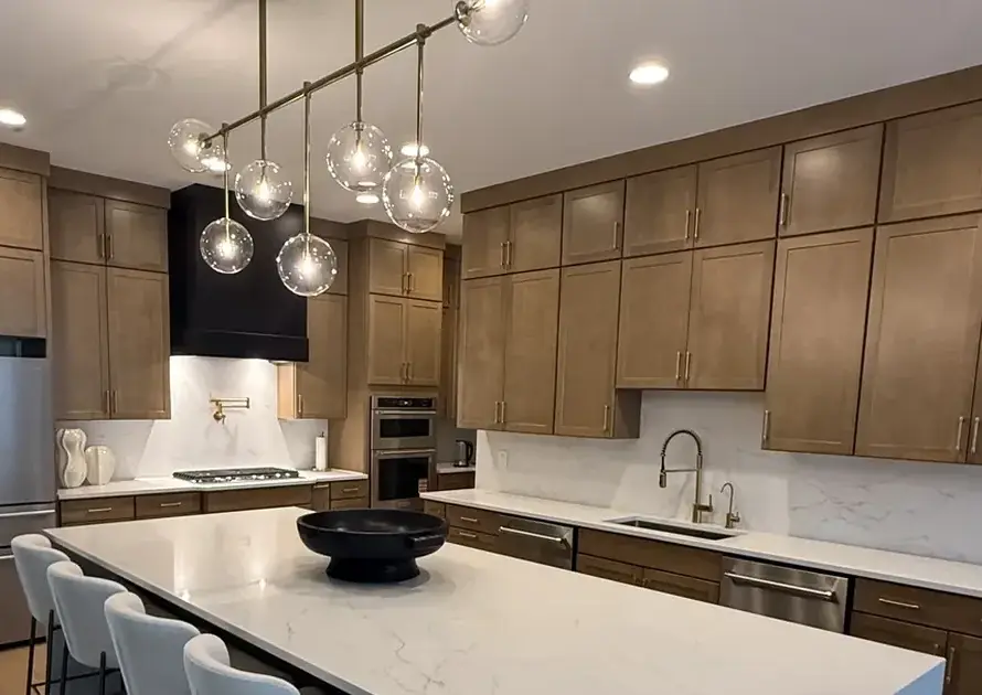 Warm wood kitchen with a white waterfall island, one of the 2026 kitchen countertop trends